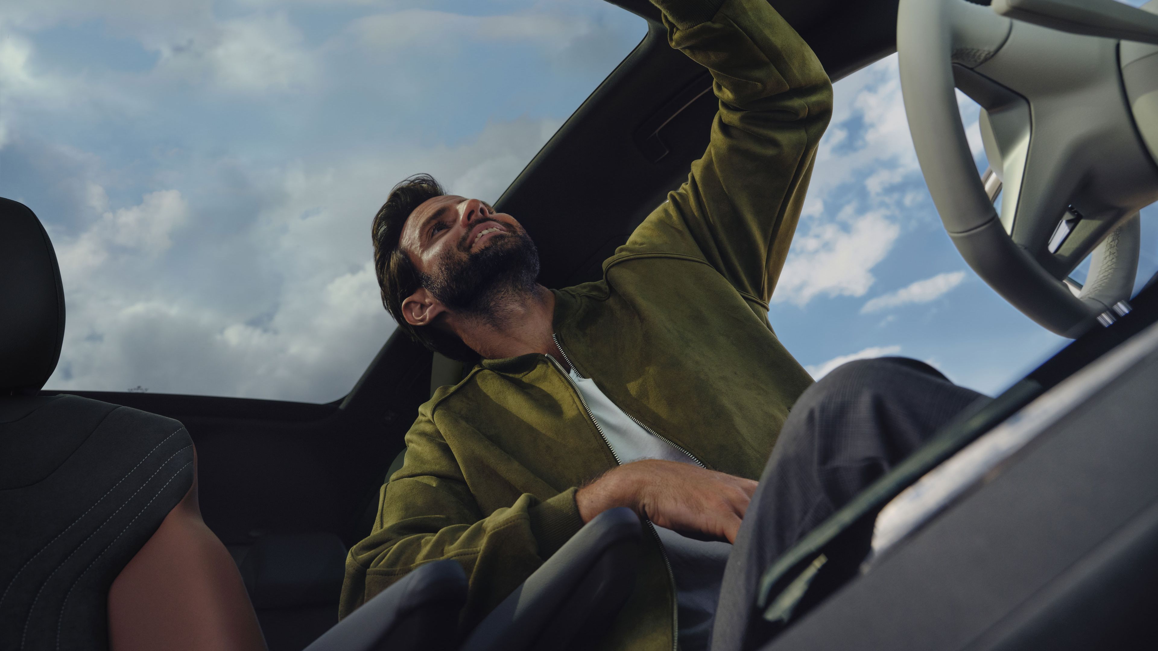 Mann öffnet das Rollo des Panoramadachs per Knopfdruck im VW ID.4