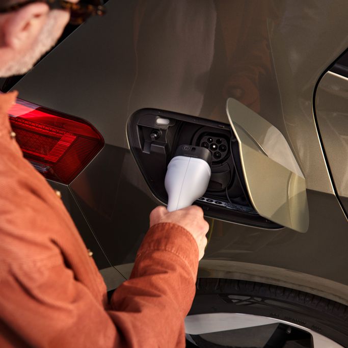 Ein Mann steckt den Ladestecker in die Ladebuchse des VW ID.3