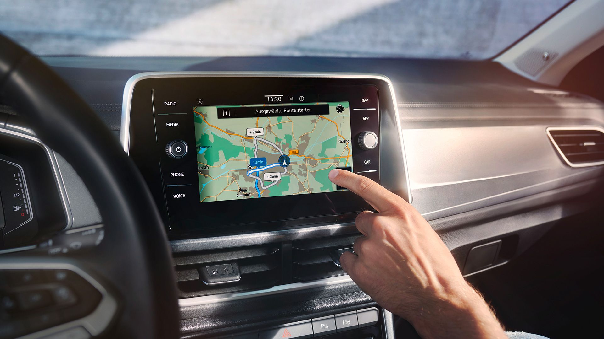 VW T-Roc Interieur, Detailansicht des Infotainment-Systems Discover Media, das gerade von einer Hand bedient wird