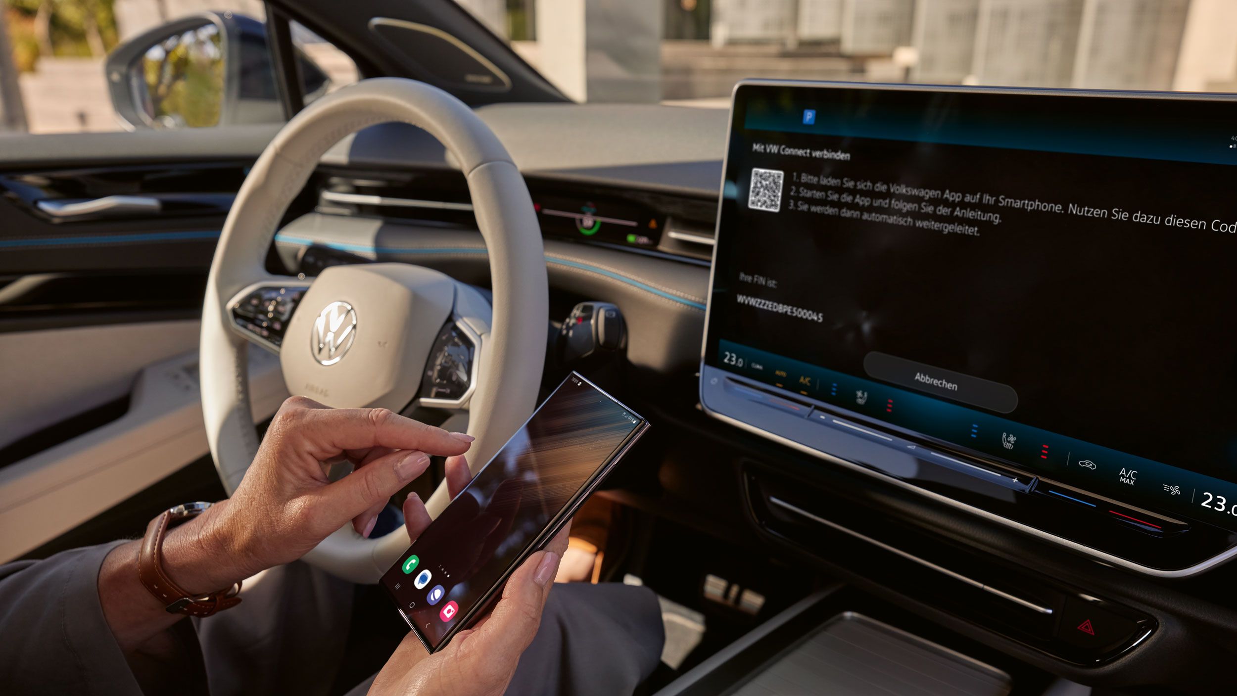 Person koppelt Smartphone mit dem VW ID.7