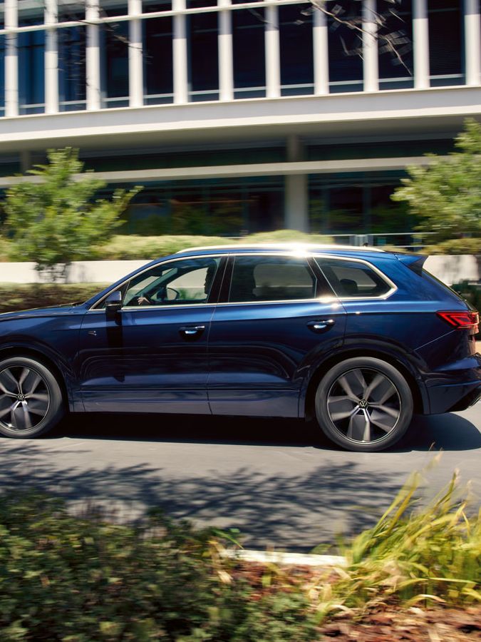Ein blauer VW Touareg fährt in einer Stadt