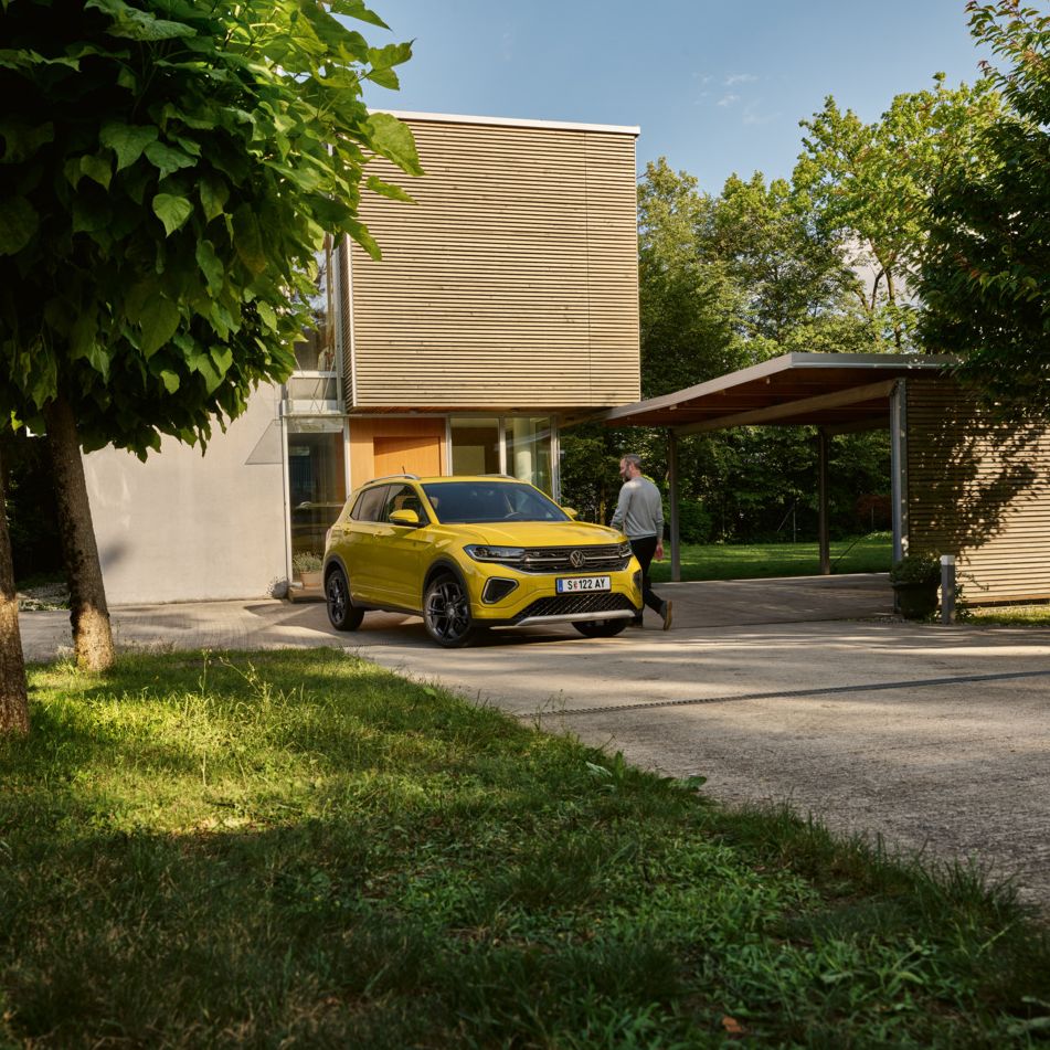 Ein VW T-Cross in gelb vor einem Einfamilienhaus