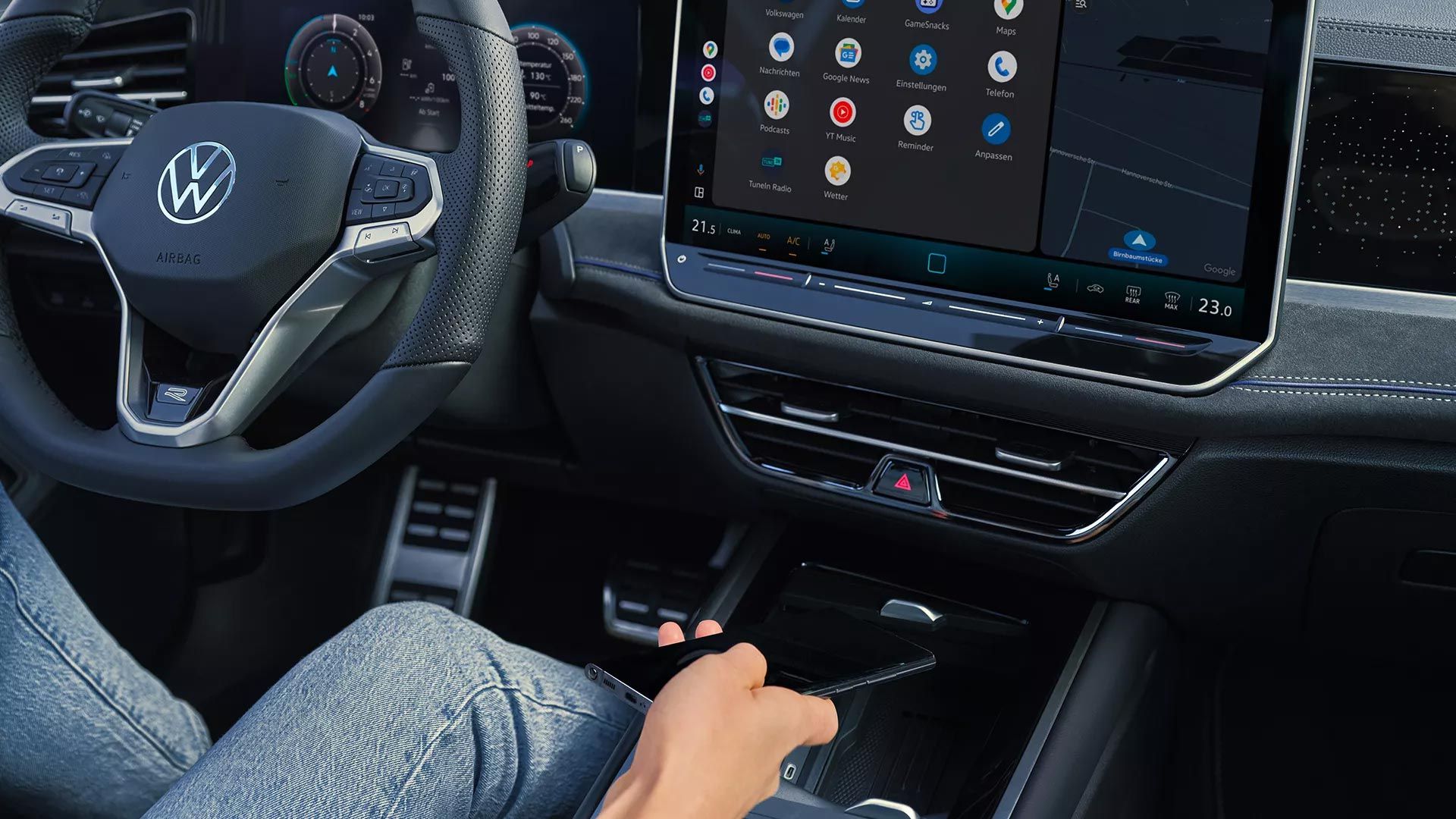 Person legt Smartphone in Ablage für Wireless Charging im VW Passat