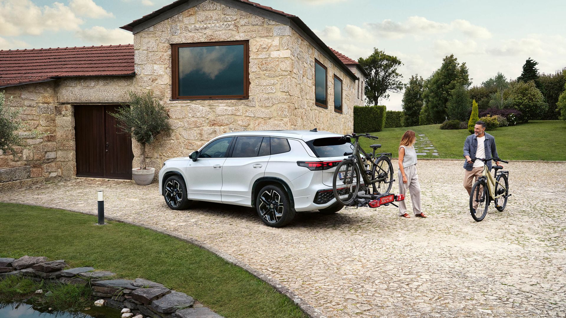 Frau und Mann laden ihre Räde auf die Anhängervorrichtung eines Tayron 