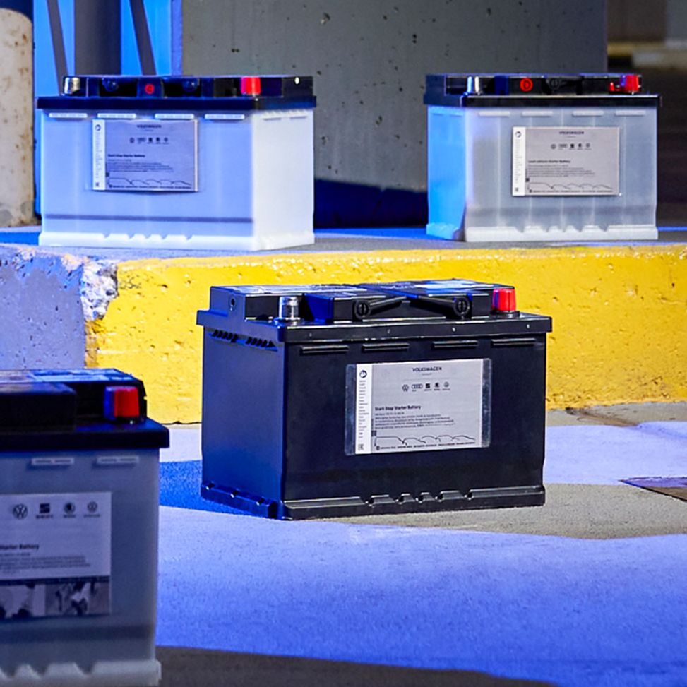 VW Batterie wird von einem Mechaniker in der VW Werkstatt ausgetauscht
