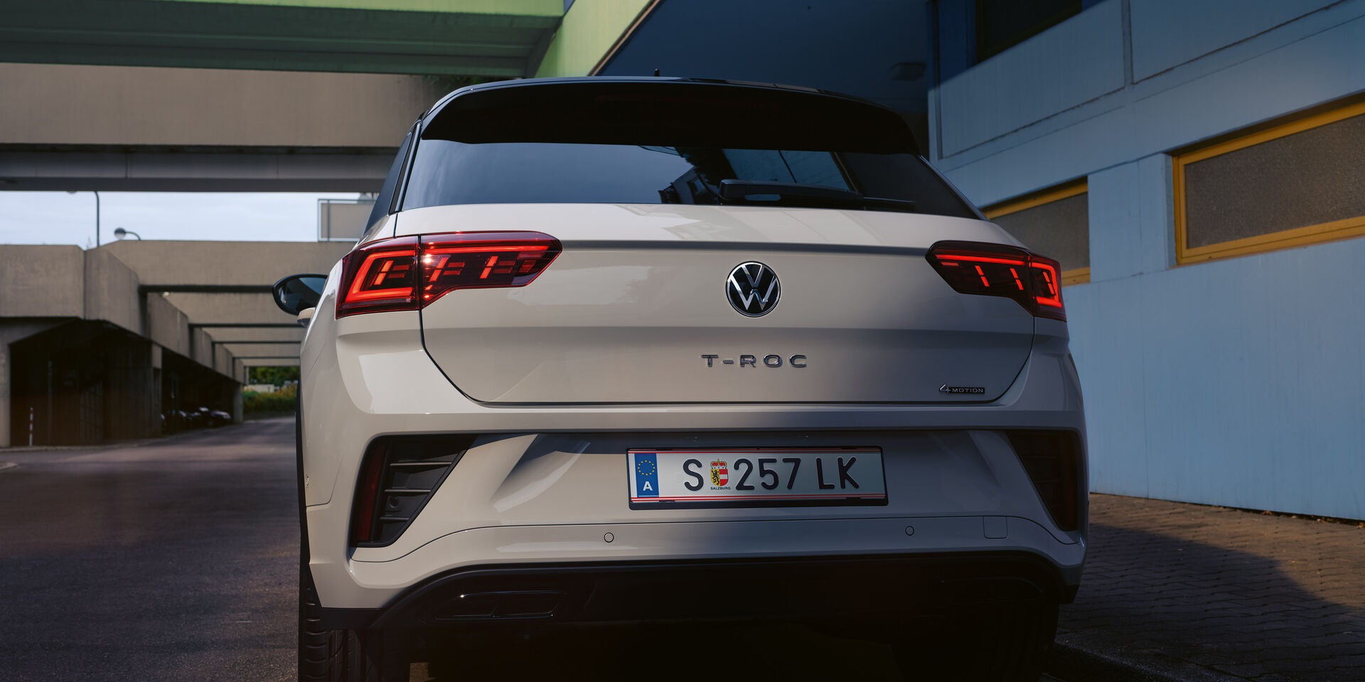 Heckansicht eines weißen VW T-Roc, parkend am Straßenrand